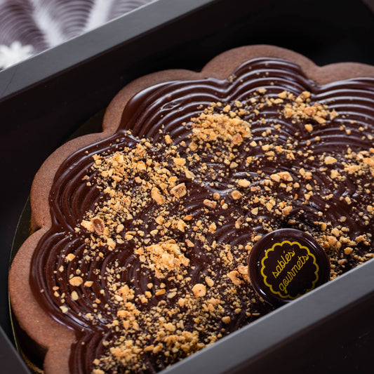 A stunning table display featuring chocolate-coated Sablés alongside fresh flowers and tableware