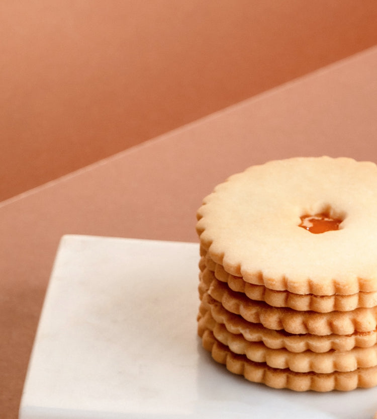 Elegant display of Jam Sablés, showcasing their buttery texture and rich apricot filling