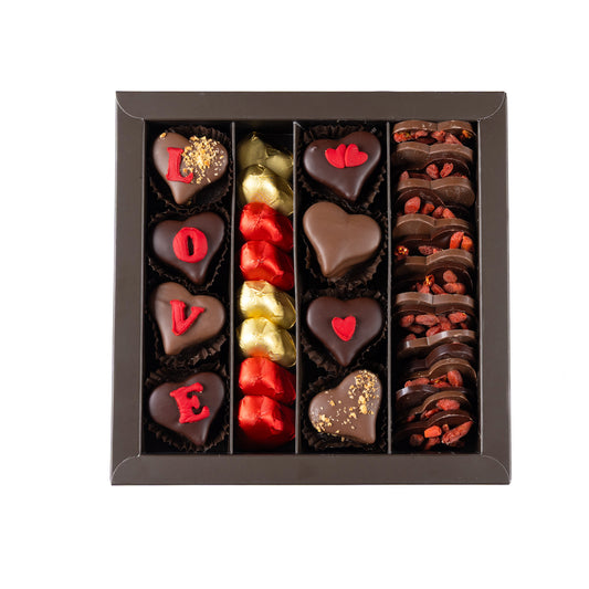 Assorted chocolate hearts and pieces in a box on a white background
