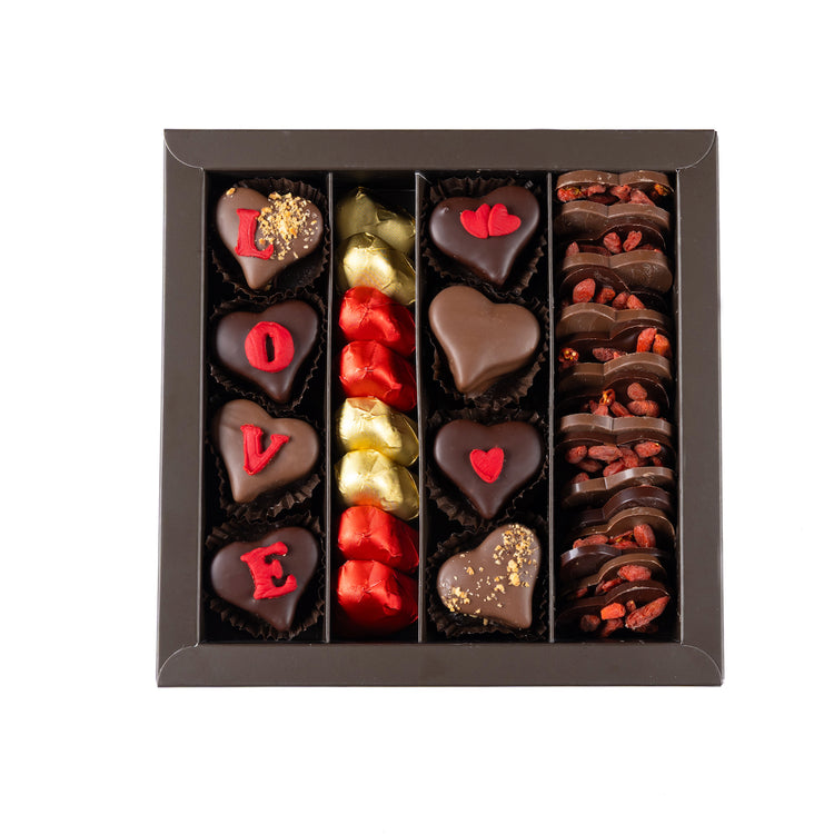 Assorted chocolate hearts and pieces in a box on a white background