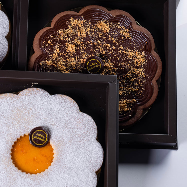 A tiered dessert stand with an assortment of Sablés, ideal for high-end celebrations or parties