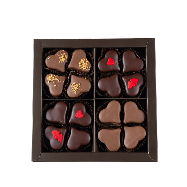 Box of heart-shaped chocolates with red and gold accents on a white background