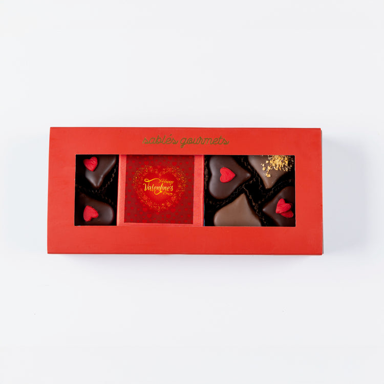 Red box of chocolates with heart designs on a white background