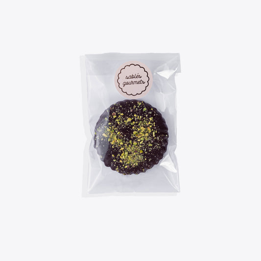 Close-up of a gourmet pistachio chocolate Sablé biscuit with vibrant green pistachio pieces