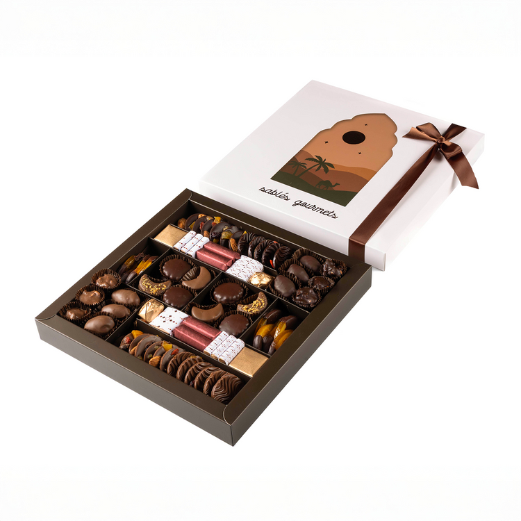 Open box of assorted chocolates with a ribbon and branded lid on a white background
