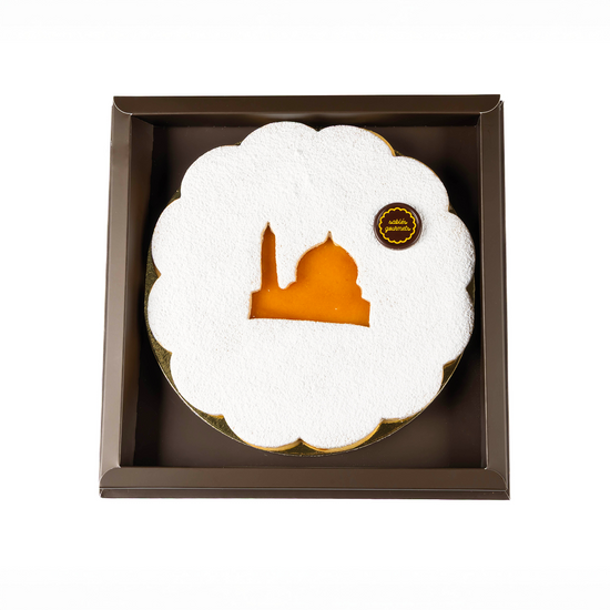 Decorative plate with a white cloud design and orange center, featuring a logo, in a brown box on a white background.