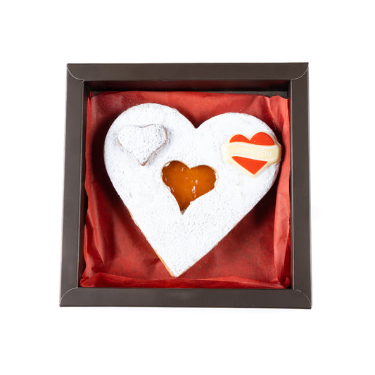 Heart-shaped cookie with a filling in a decorative box on a white background