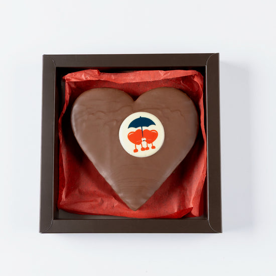 Heart-shaped chocolate in a box with a visible brand logo on a white background