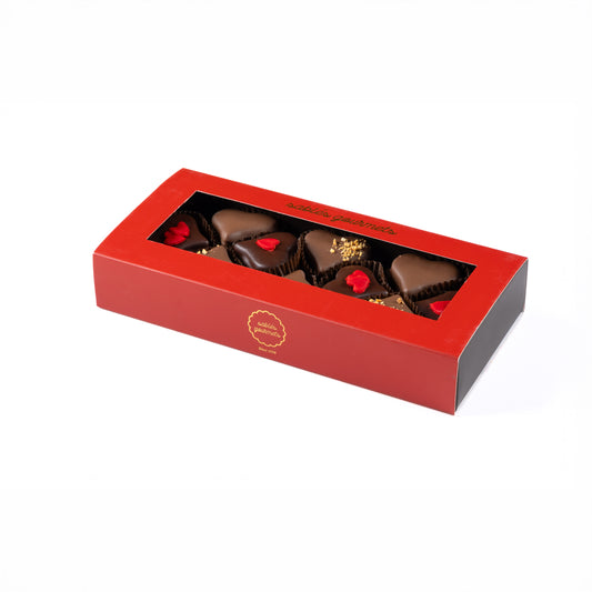 Red chocolate box with four chocolate pieces inside on a white background