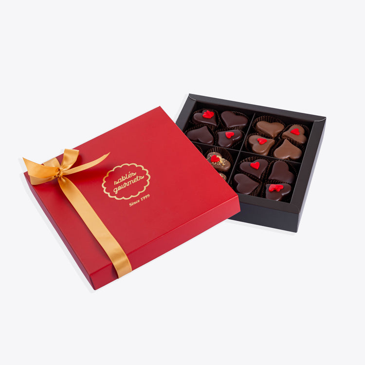 A luxurious box of heart-shaped sablés, featuring milk, hazelnut, and dark chocolate flavors.